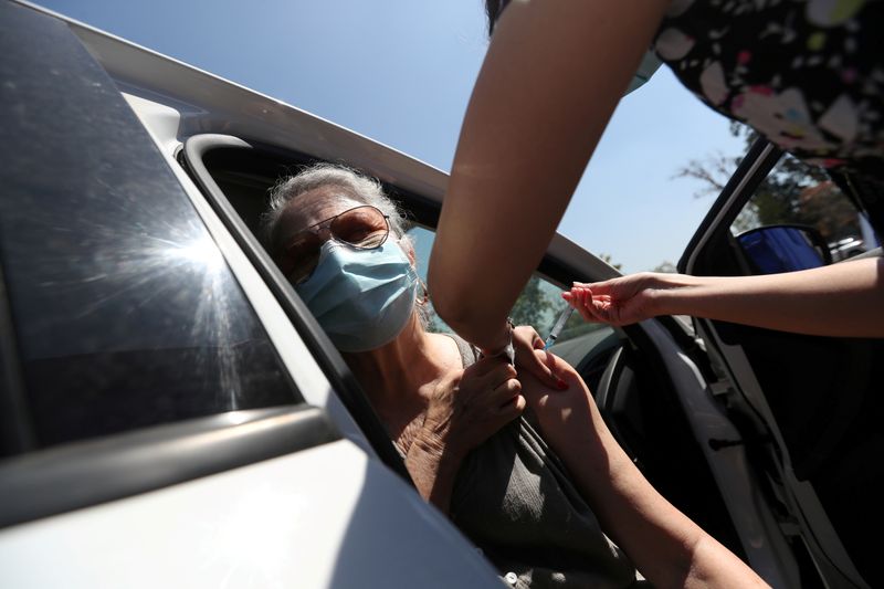 &copy; Reuters. IMAGEN DE ARCHIVO. Una trabajadora de la salud administra una dosis de la vacuna CoronaVac contra el COVID-19 en un centro de vacunación en automóviles, en Santiago, Chile