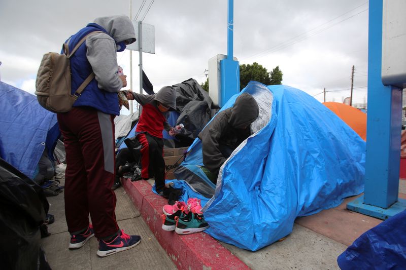 &copy; Reuters. An asylum-seeking migrant talks to her children at an encampment of Mexican and Central American migrants, at El Chaparral crossing port with the U.S., in Tijuana