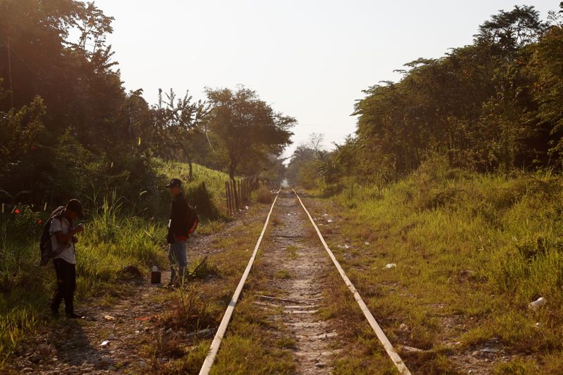 © Reuters. A group of Central American migrants rests along the railway track on their way to the United States