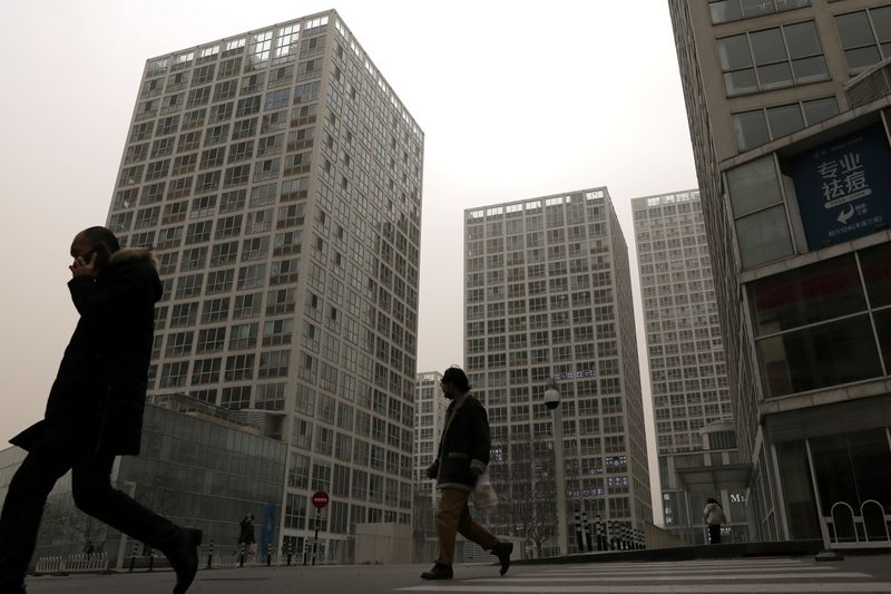 &copy; Reuters. FILE PHOTO: People walk past an office and commercial complex in Beijing&apos;s Central Business District (CBD)