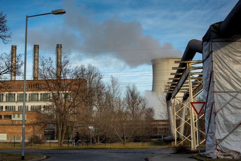 &copy; Reuters. FILE PHOTO: A woman cycles past a power station that is attached to the ArcelorMittal steel factory in Eisenhuettenstadt