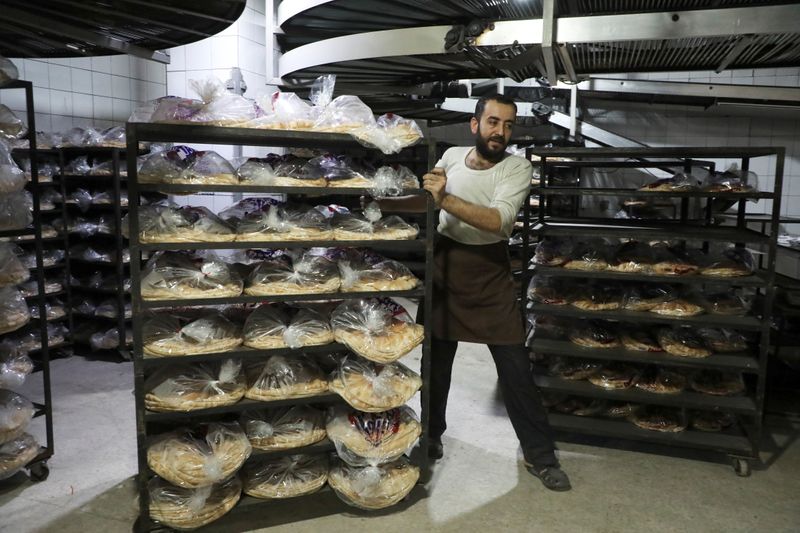 © Reuters. A worker moves stacks of bread at a bakery in Beirut