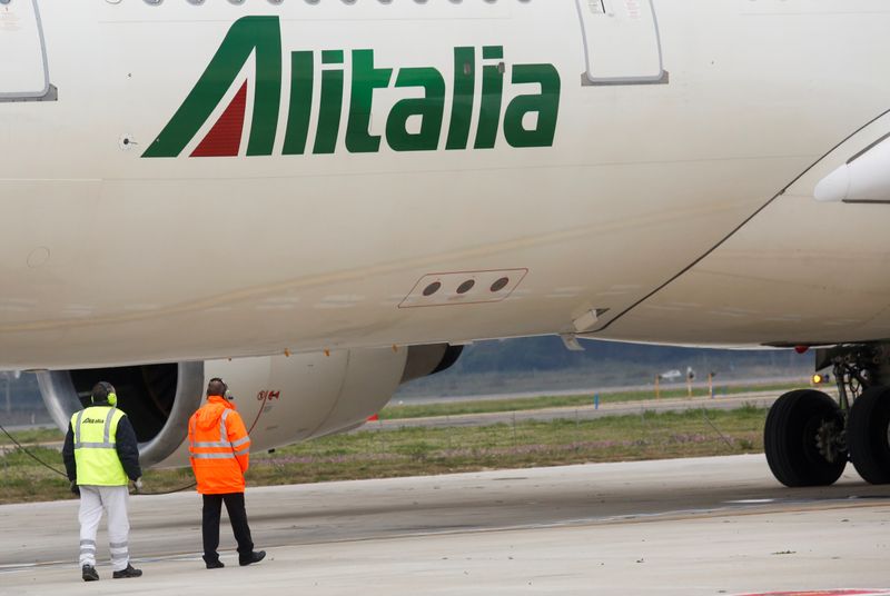 &copy; Reuters. FILE PHOTO: Two workers are seen next to an Alitalia plane at Fiumicino airport in Rome, Italy