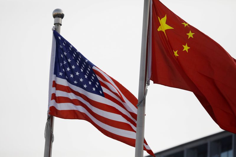 © Reuters. FILE PHOTO: Chinese and U.S. flags flutter outside the building of an American company in Beijing