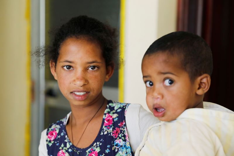 © Reuters. Mibrak Hailu, who says her parents were killed by Eritrean soldiers, holds one of her  five siblings at a temporary house, Tigray region