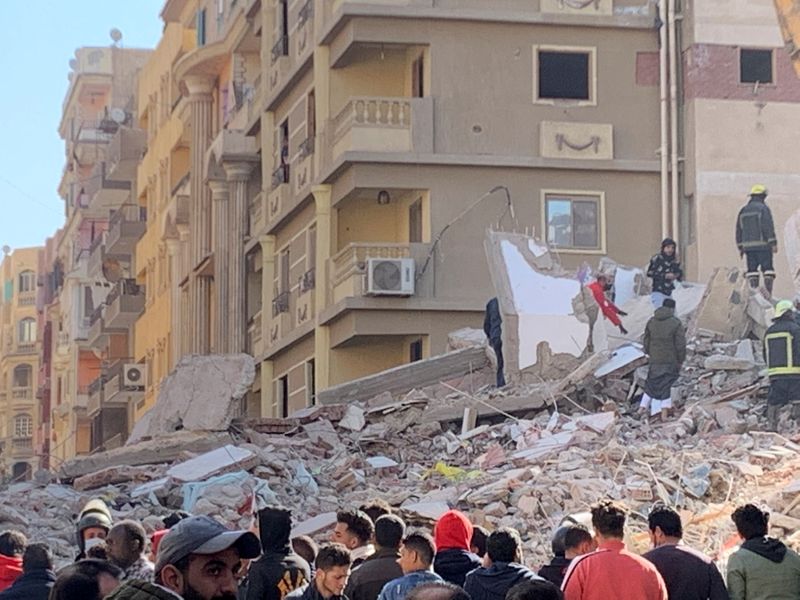 &copy; Reuters. People inspect the area where a building was collapsed in Gesr al-Suez, Cairo