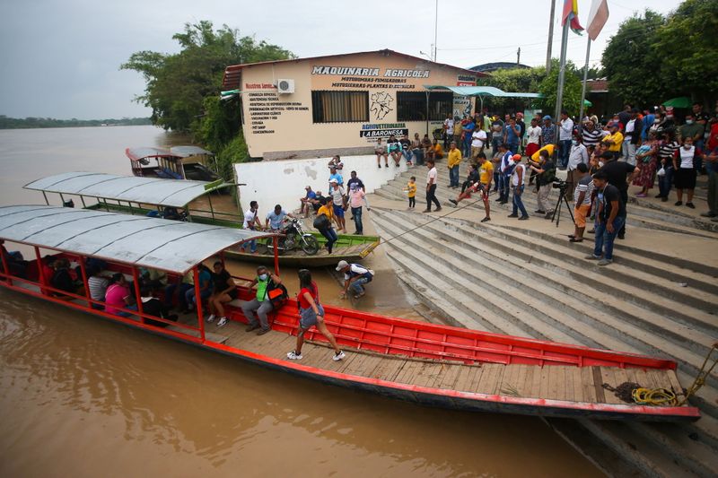 © Reuters. Venezuelan migrants are seen on the banks of the Arauca river after fleeing their country due to military operations, according to the Colombian migration agency, in Arauquita