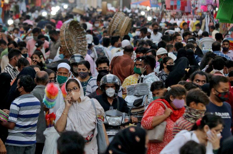 &copy; Reuters. FILE PHOTO: People wearing protective masks crowd a marketplace amidst the spread of COVID-19 in Mumbai