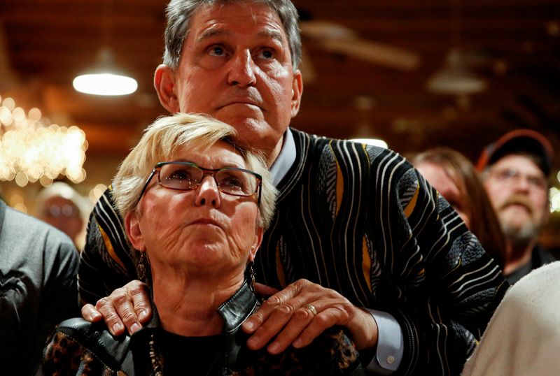 © Reuters. Senator Manchin and his wife watch West Virginia University play Texas University in football in Peach Creek