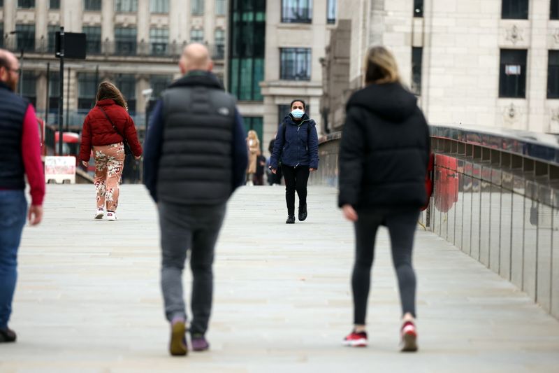 &copy; Reuters. People socially distance as they walk across London Bridge, in London