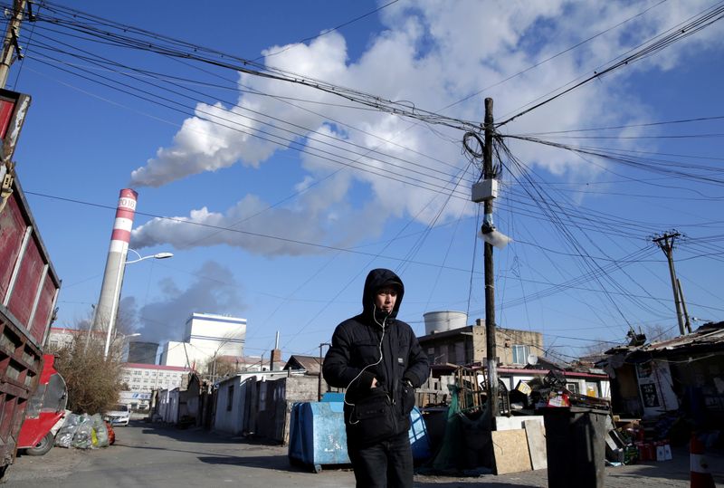 &copy; Reuters. FILE PHOTO: A man walks near a coal-fired power plant in Harbin
