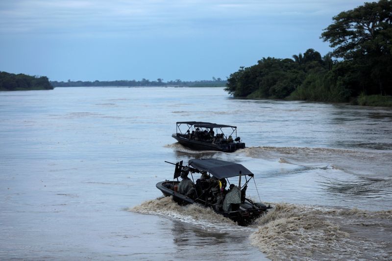 © Reuters. Colombian soldiers patrol by boat on the Arauca River, at the border between Colombia and Venezuela, as seen from Arauquita