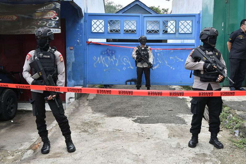 &copy; Reuters. Armed police officers stand guard outside a house during a raid in Bekasi