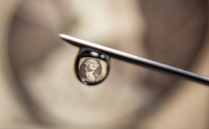 &copy; Reuters. U.S. one dollar banknote is reflected in a drop on a syringe needle in this illustration photo