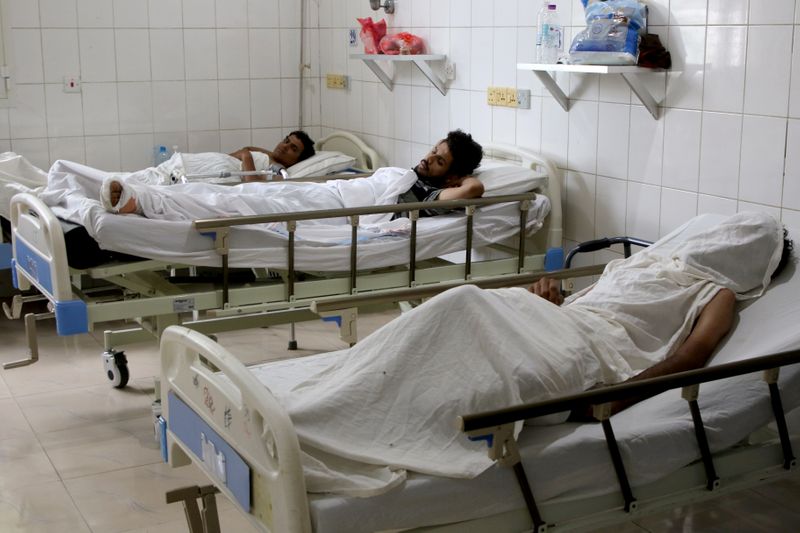 © Reuters. FILE PHOTO: People injured in an attack on Aden airport rest at a hospital in Aden