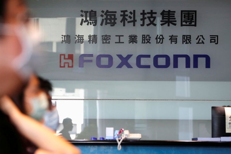 &copy; Reuters. FILE PHOTO: People wear masks to protect themselves from coronavirus disease (COVID-19) while listening to the annual general meeting at the lobby of Foxconn&apos;s office in Taipei