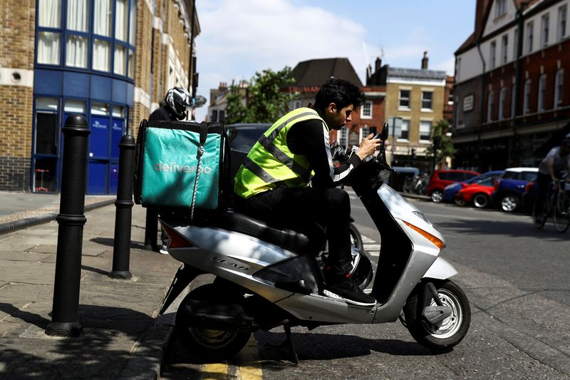 &copy; Reuters. FILE PHOTO: A Deliveroo scooter driver takes a break between deliveries in London