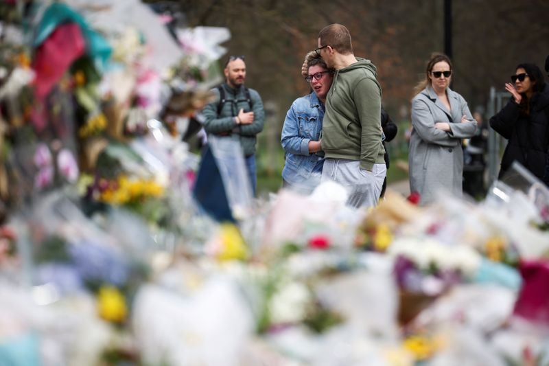 © Reuters. FILE PHOTO: People observe a memorial site at the Clapham Common Bandstand, following the kidnapping and murder of Sarah Everard, in London