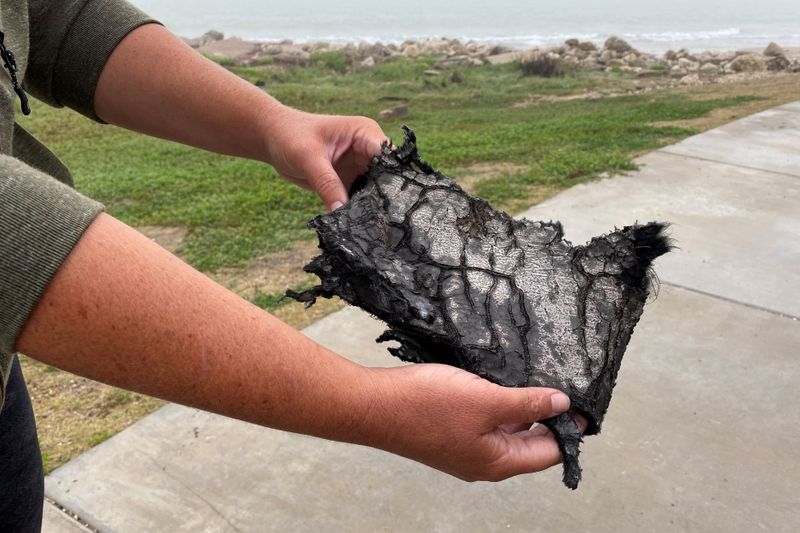 &copy; Reuters. A spectator holds a piece of debris which was blown 5 miles from the site where SpaceX test rocket SN11 exploded upon landing, in Boca Chica