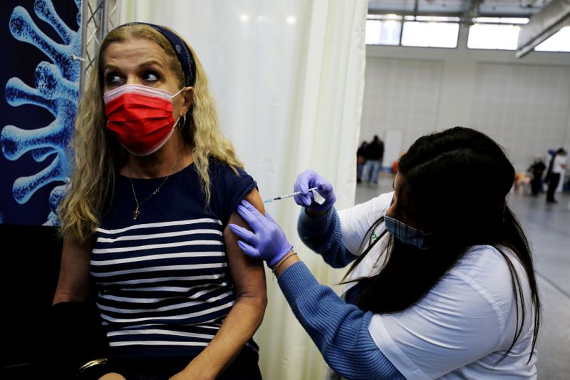 &copy; Reuters. Mulher recebe vacina contra Covid-19 em Petah Tikva, cidade de Israel