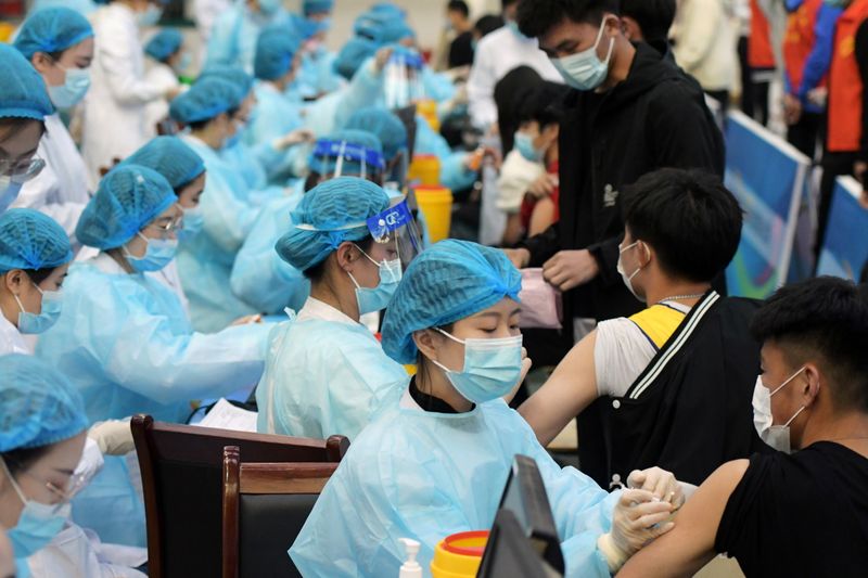 &copy; Reuters. Medical workers inoculate students with the vaccine against the coronavirus disease in Qingdao