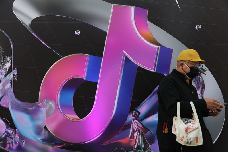 &copy; Reuters. Man stands near a giant sign of Chinese company ByteDance&apos;s app TikTok, known locally as Douyin, during China Fashion Week, in Beijing