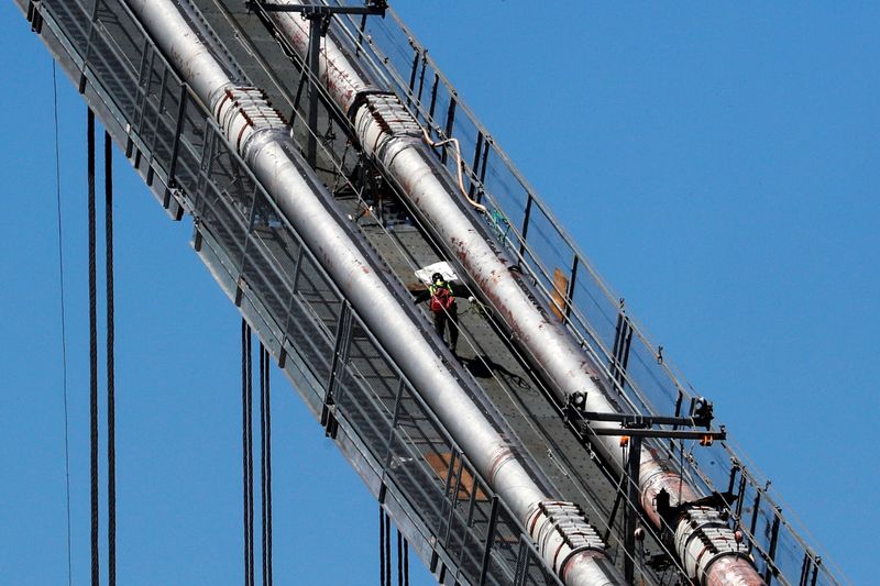 © Reuters. A construction worker scales the northeast cables of the George Washington Bridge duering reconstruction in New York