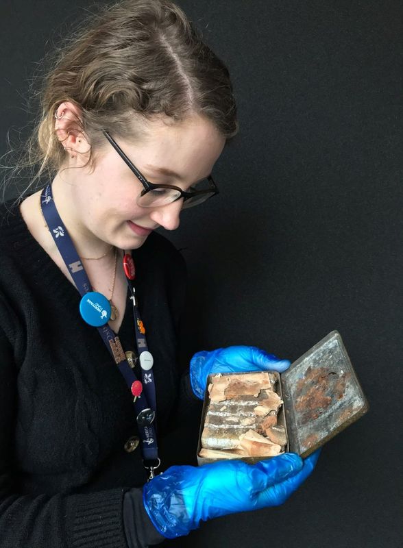 © Reuters. Katherine Bridges, Senior House and Collections Officer at the National Trust, holds a 121-year-old tin of chocolate from a batch commissioned by Queen Victoria for British troops fighting in South Africa, in an undated photo at Oxburgh Hall
