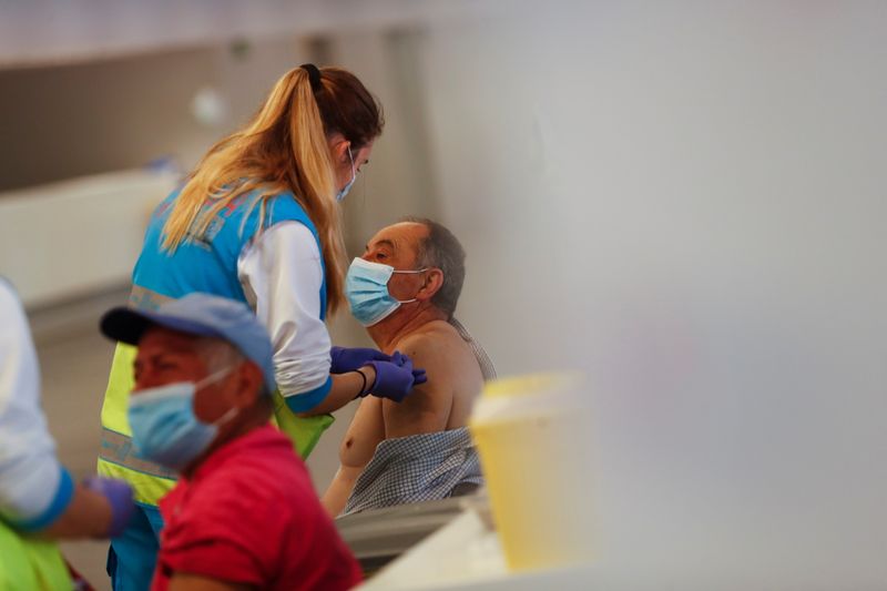 © Reuters. Man receives an injection with AstraZeneca's COVID-19 vaccine at a vaccination centre, in Madrid