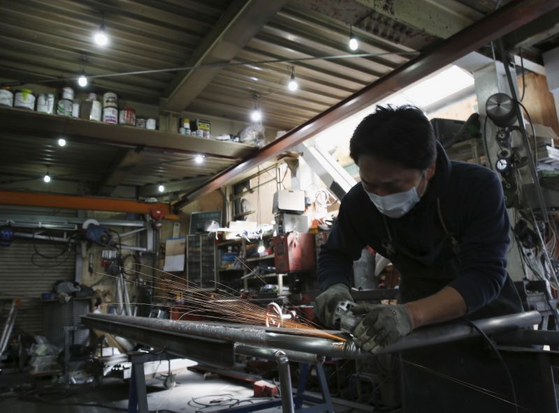 &copy; Reuters. An engineer makes an arm rail for residential buildings inside a metal processing factory at an industrial zone in downtown Tokyo