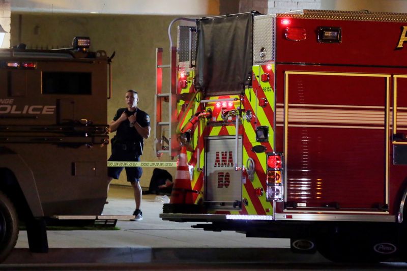 © Reuters. A police officer stands in front of a building after a shooting at an office building in Orange, California