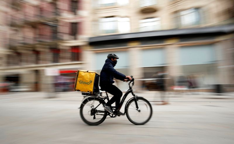 &copy; Reuters. FILE PHOTO: Glovo deliver rider passes by a pedestrian area in Barcelona
