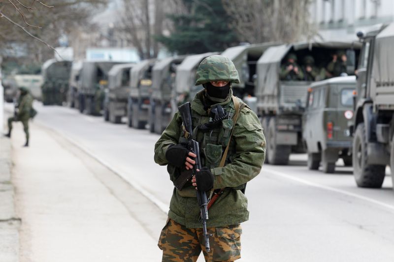 &copy; Reuters. Militares armados esperan en vehículos del ejército ruso frente a un puesto de guardia fronterizo ucraniano en la ciudad de Balaclava