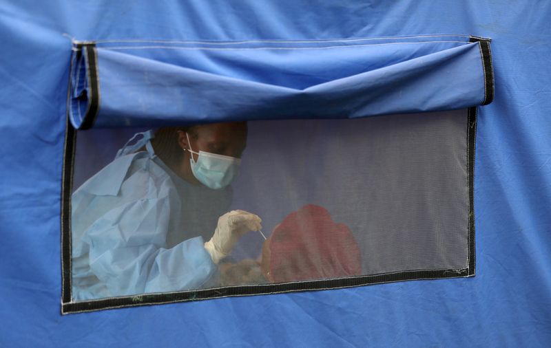 &copy; Reuters. FOTO DE ARCHIVO: Una trabajadora sanitaria somete a una persona a un test de COVID-19 en Lenasia