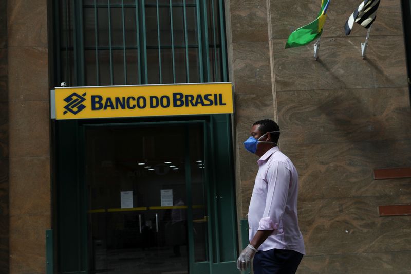 &copy; Reuters. A man wearing a protective face mask and gloves walks in front of Banco do Brasil (Bank of Brazil) during the coronavirus disease (COVID-19) outbreak in Sao Paulo