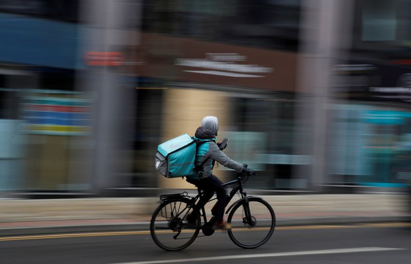 &copy; Reuters. FILE PHOTO: A deliveroo delivery driver cycles through the centre of Manchester