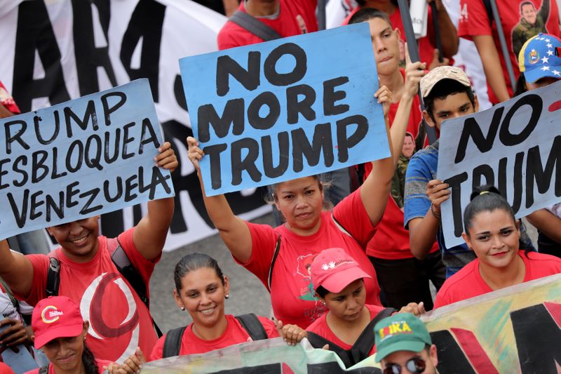 © Reuters. FILE PHOTO: Supporters of Venezuela's President Nicolas Maduro hold anti-trump banners during a rally against the U.S. sanctions on Venezuela, in Caracas