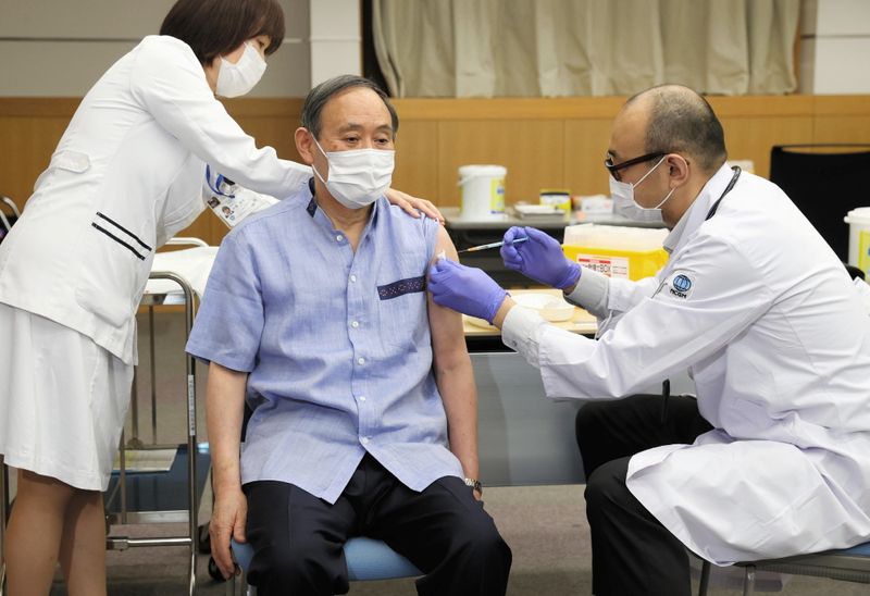 &copy; Reuters. El primer ministro de Japón, Yoshihide Suga, recibe su primera dosis de la vacuna anti-COVID-19 de Pfizer-BioNtech en el Centro Nacional de Salud y Medicina Global en Tokio