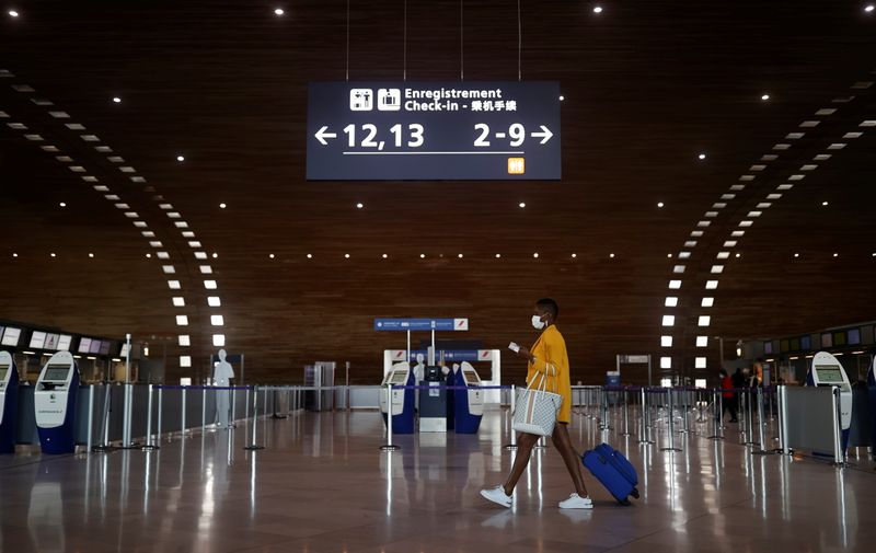 &copy; Reuters. A woman makes her way in the departures area of the Terminal 2E at Charles-de-Gaulle airport in Roissy