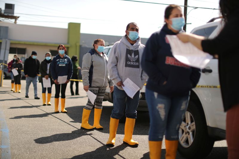 © Reuters. People wait in line for coronavirus disease (COVID-19) vaccinations at a mobile vaccination drive for essential food processing workers at Rose & Shore, Inc., in Vernon, Los Angeles