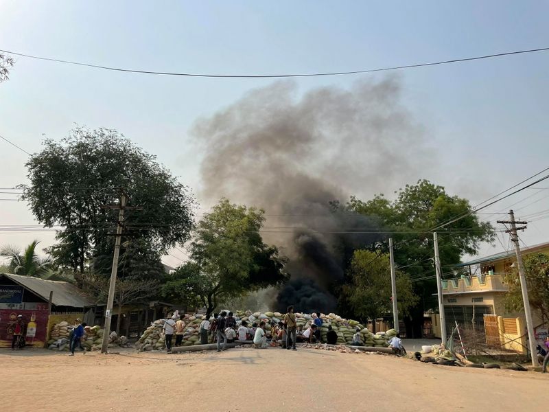 © Reuters. Protesters gather behind a barricade during a protest against the military coup, in Monywa, Myanmar