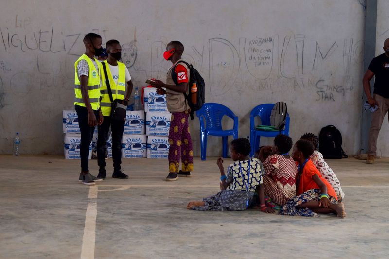 &copy; Reuters. People look on as aid workers consult a person at a displacement centre in Pemba