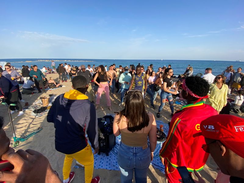 © Reuters. People dance at Barceloneta beach, in Barcelona