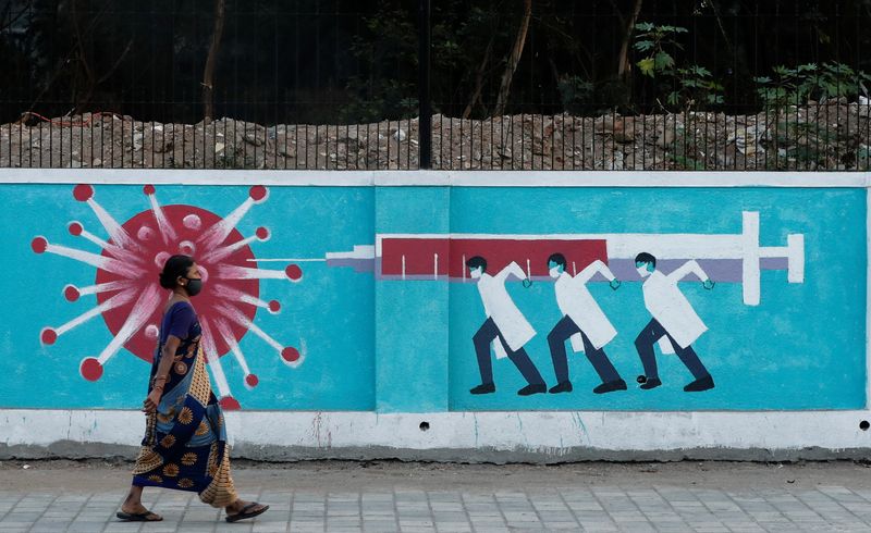 &copy; Reuters. Woman walks past a graffiti amidst the spread of the coronavirus disease, in Mumbai