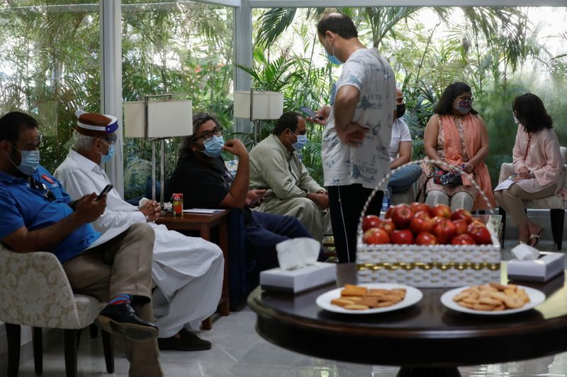 © Reuters. Residents sit in a waiting area after getting a commercial dose of Russia's Sputnik V coronavirus disease (COVID-19) vaccine, at a private hospital in Karachi