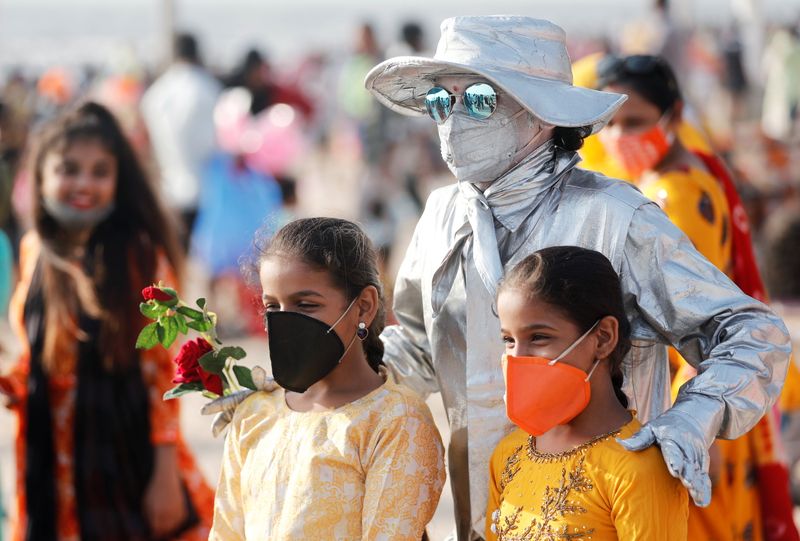 &copy; Reuters. People pose with a performance artist at a beach amidst the spread of the coronavirus disease (COVID-19) in Mumbai