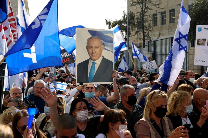 &copy; Reuters. Supporters of Israeli Prime Minister Benjamin Netanyahu, wave flags and hold a placard depicting Netanyahu, during a rally as Netanyahu&apos;s corruption trial resumes, near Jerusalem&apos;s District Court