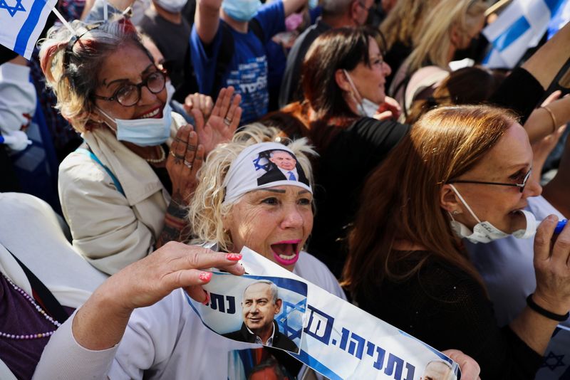 &copy; Reuters. A supporter of Israeli Prime Minister Benjamin Netanyahu, wearing a headband with an image of Netanyahu, shouts slogans during a rally as Netanyahu&apos;s corruption trial resumes, near Jerusalem&apos;s District Court
