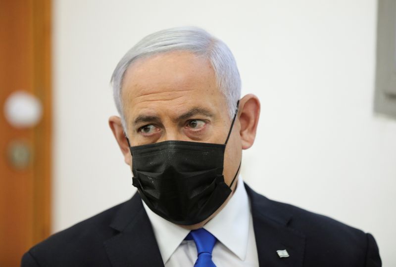© Reuters. Israeli Prime Minister Benjamin Netanyahu, wearing a face mask, looks on as his corruption trial resumes, at Jerusalem's District Court