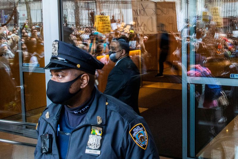 &copy; Reuters. A NYPD officer stands guard as people march during a Stop Asian Hate rally in New York